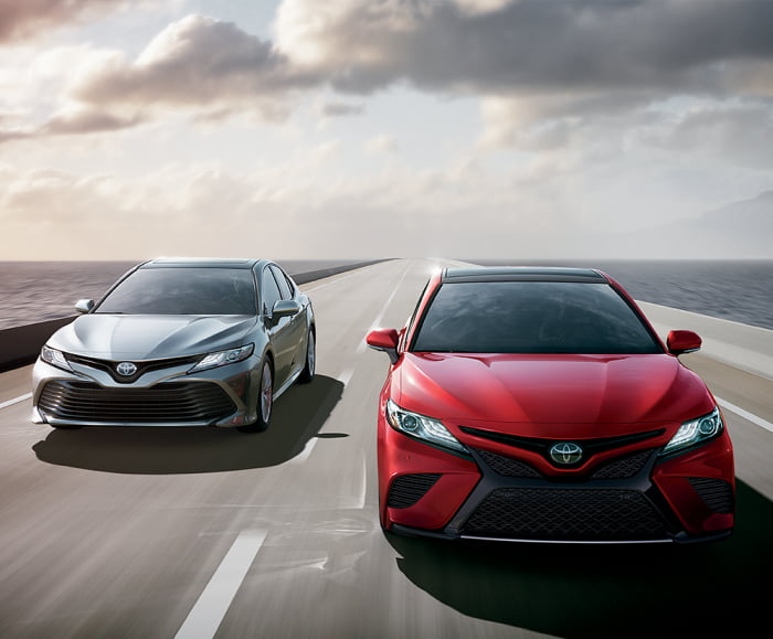 Two-car front action shot of 2019 XSE V6 in Supersonic Red and XLE Hybrid in Celestial Silver Metallic.