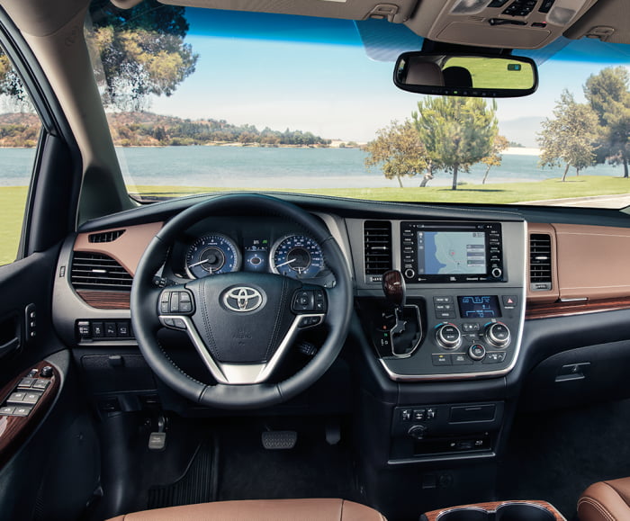 Wide static shot of dashboard of Toyota Sienna with Chestnut trim and white accent stitching.