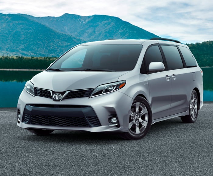 Wide static shot of the Toyota Sienna in Celestial Silver Metallic with a mountain forest in the background.