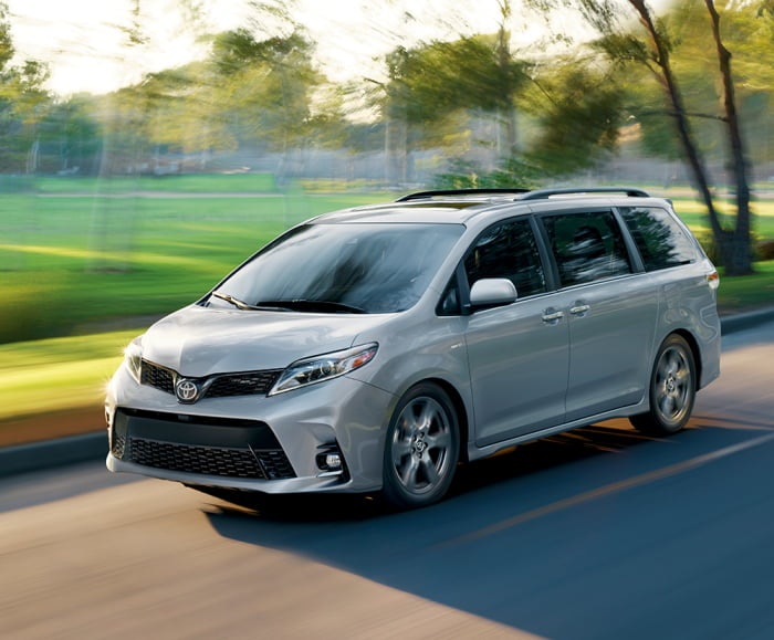 Driver's-side corner shot of the 2019 Sienna in Celestial Silver Metallic driving down a sunny road.